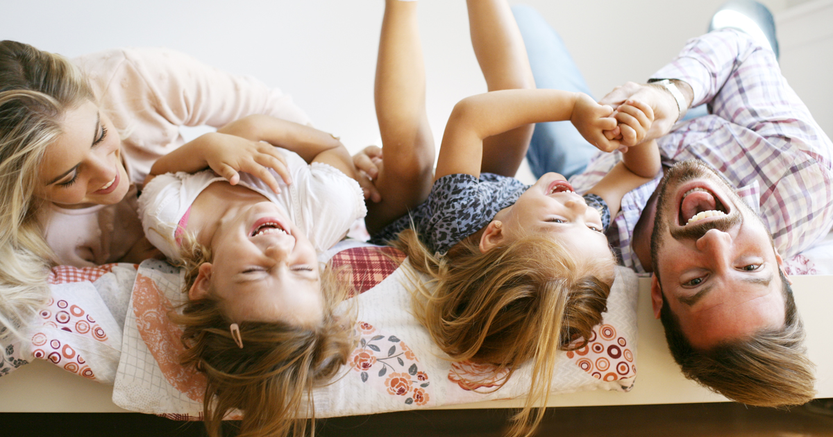 Family playing on bed